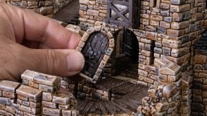 A 3D printed and painted doorway being inserted into a castle for dnd and wargaming